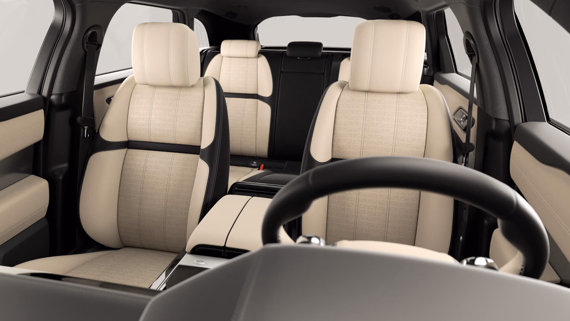3D render of the JLR L560 cabin interior with cream and black leather seats, dashboard and steering wheel viewed from the rear.